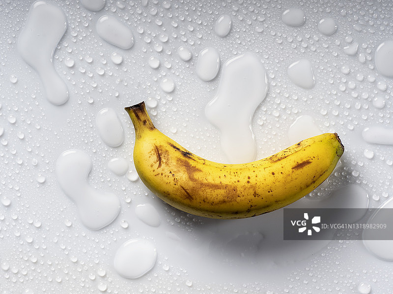 金丝雀香蕉在白色的背景和水滴。图片素材