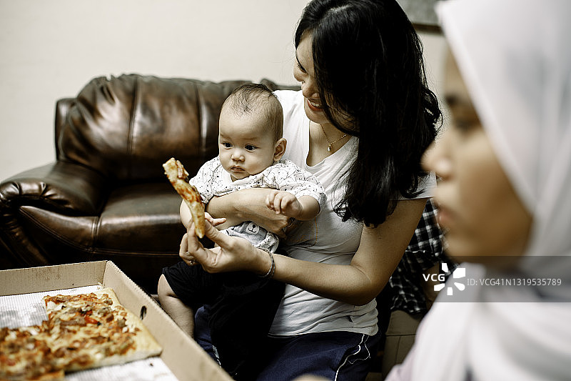 亚洲家庭在家吃披萨图片素材