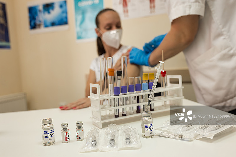 医生在接种中心为成熟妇女接种疫苗图片素材