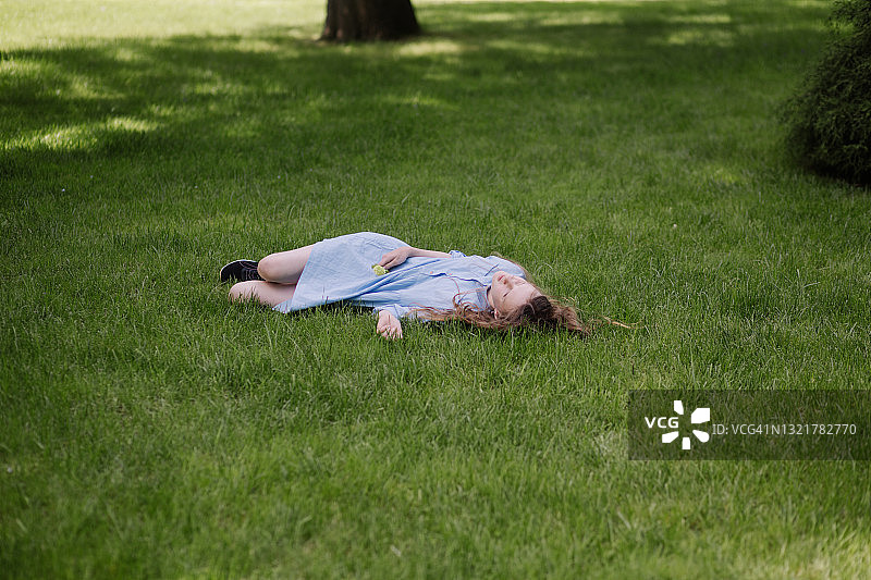 穿蓝衣服的女孩躺在草地上图片素材