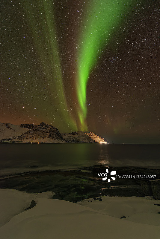 冬天，挪威北部Senja岛的斯坦因峡湾和周围的山脉在夜晚观赏北极光(北极光)。图片素材