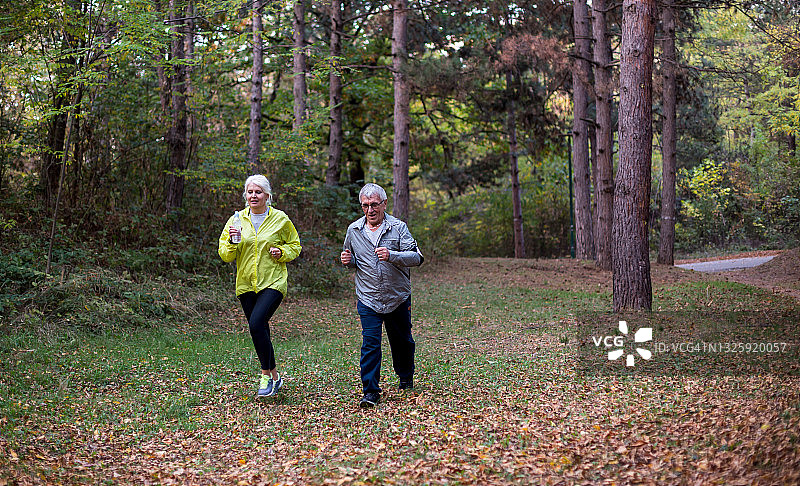 一对老年夫妇在森林里慢跑图片素材