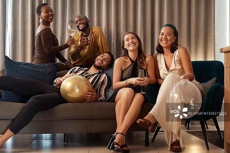 这张照片拍摄的是一群不同的朋友坐在客厅里一起参加新年聚会图片素材