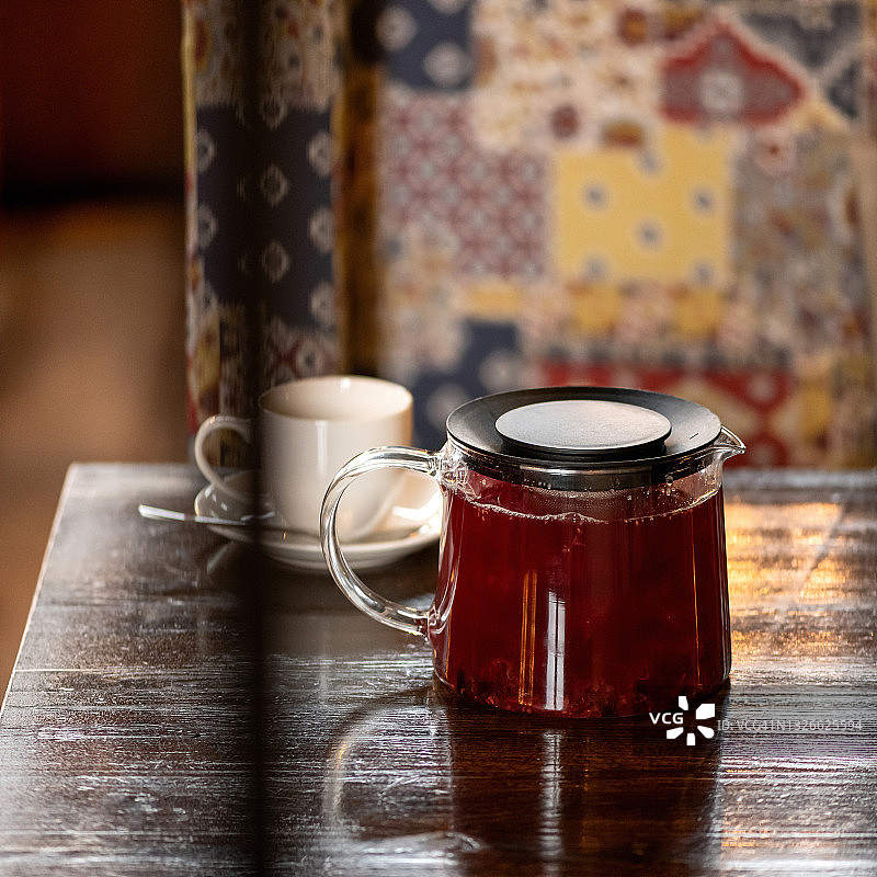 木桌上放着杯子，上面放着泡好的红茶玻璃茶壶。物体在模糊的背景与复制空间，软焦点图片素材