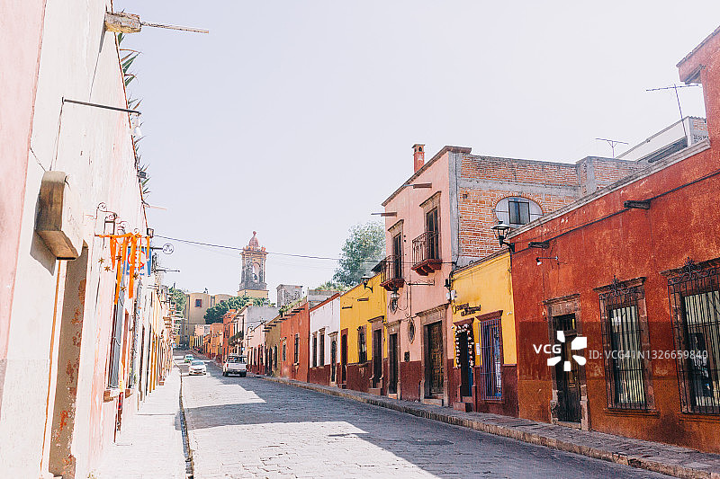 在圣米格尔德阿连德(San Miguel de Allende)，空荡荡的道路两旁是五颜六色的殖民风格房屋图片素材