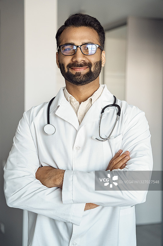 印度男子医生的肖像，医务人员站着双臂交叉图片素材