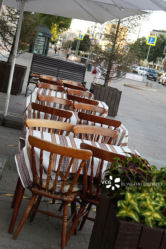 空的人行道咖啡馆与陶土木制椅子和彩色桌布图片素材