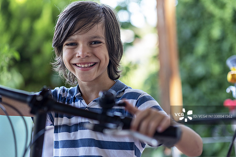 快乐的小男孩用自行车铃图片素材