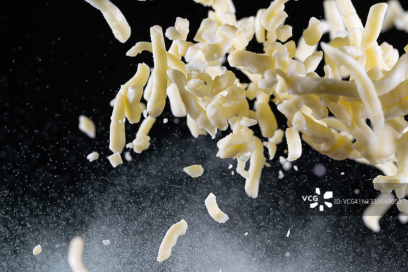 马苏里拉奶酪碎片在空中高速同步捕捉。“n图片素材
