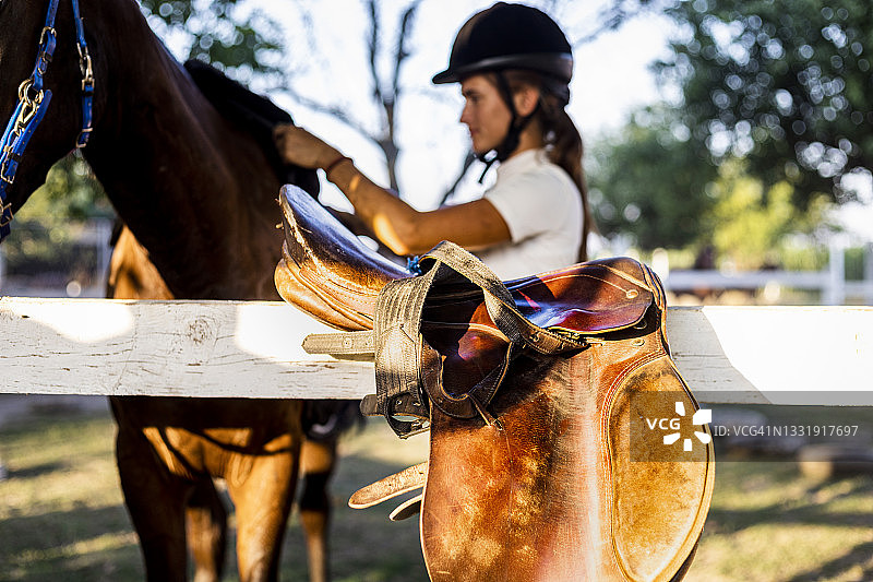 漂亮的年轻女人穿着骑马服抚摸着她的马图片素材