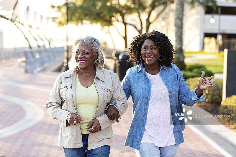 两名资深非裔美国妇女手挽着手走着图片素材