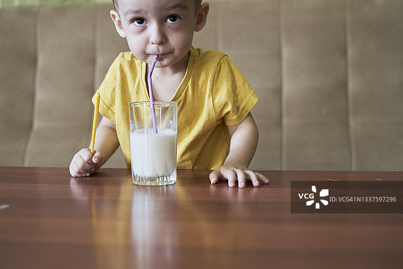 一个用吸管喝牛奶的小孩图片素材