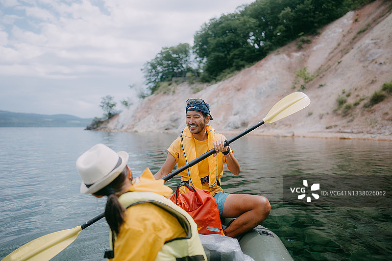 日本北海道，一名男子正和孩子在湖上划皮划艇图片素材