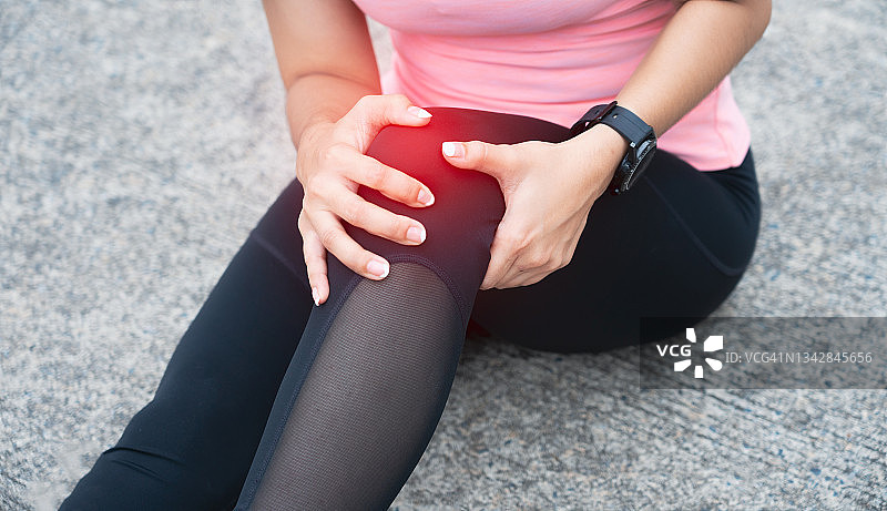 膝盖疼痛。运动损伤，女性在户外运动时膝盖疼痛。女子跑步运动员跑步膝盖损伤的研究。图片素材