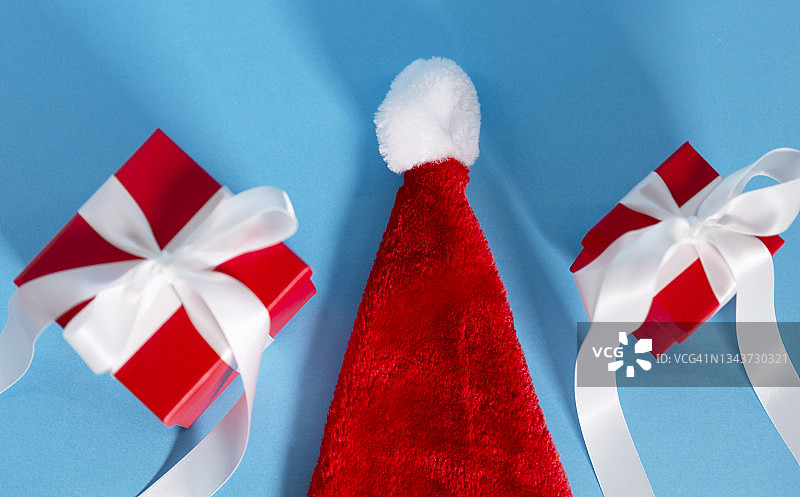 圣诞装饰圣诞帽和圣诞礼品盒以蓝色为背景图片素材