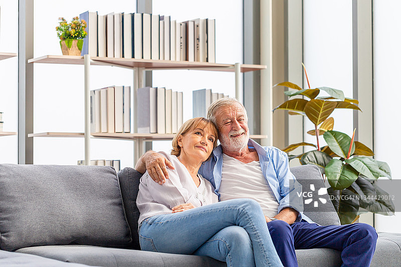 客厅里幸福老夫妇的肖像，老女人和男人在舒适的沙发上放松，幸福的家庭概念图片素材