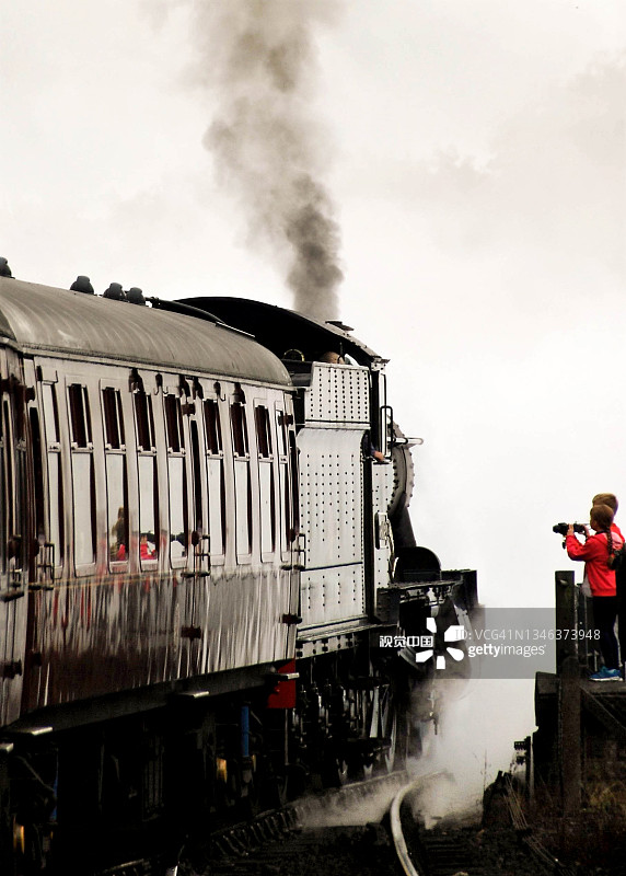 老式蒸汽火车被白色的烟雾包围着图片素材