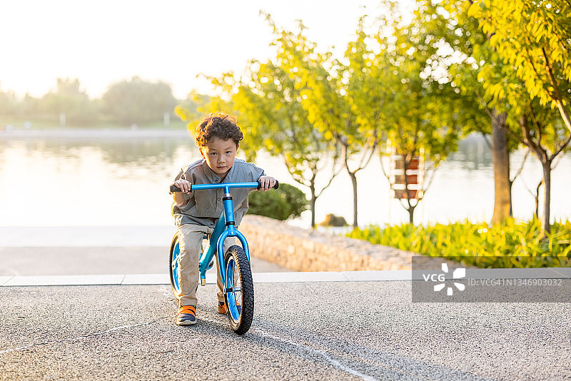 一个小男孩骑着自行车图片素材