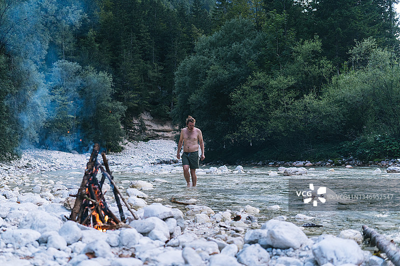 夏天，一个年轻人走到河边图片素材