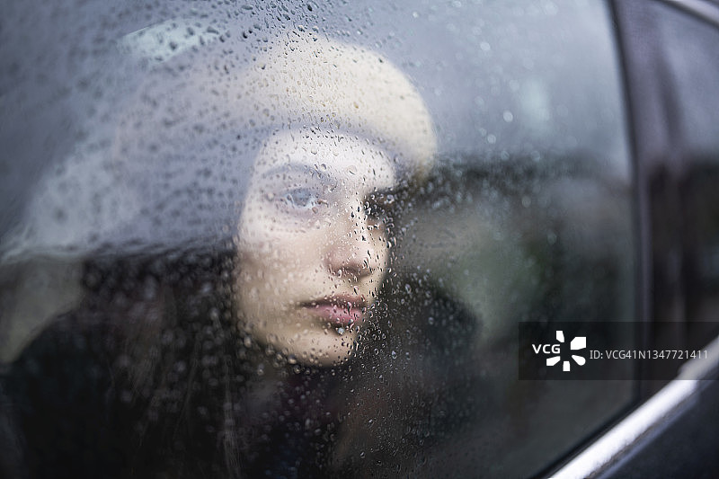 下雨天车里的悲伤年轻女子图片素材