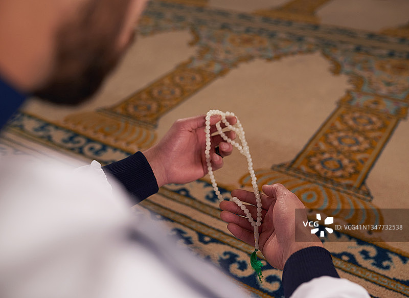 一名穆斯林男子在清真寺手持念珠的特写镜头图片素材