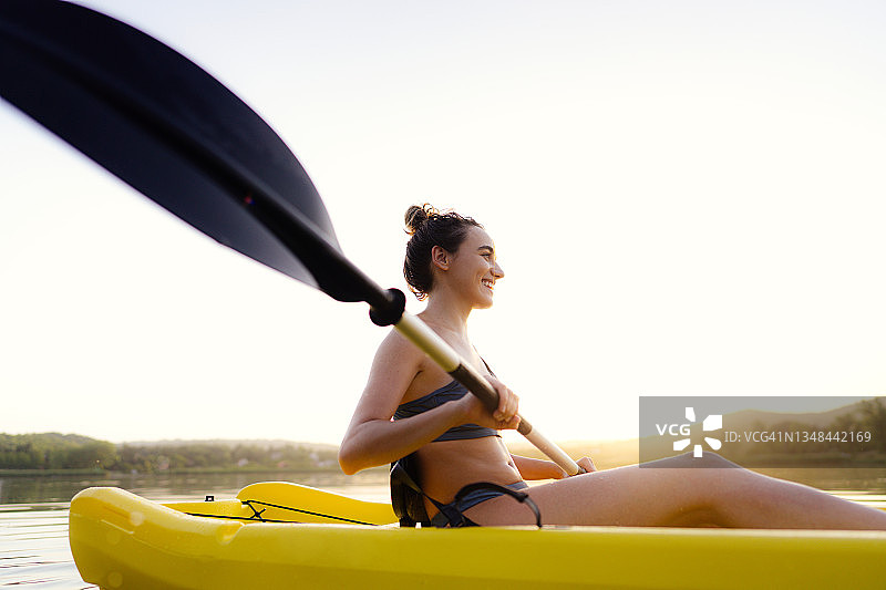 一个在湖上划皮艇的年轻女子图片素材