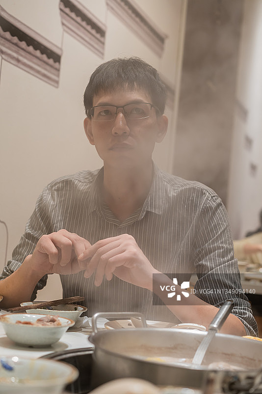 一名亚洲男子在牛肉火锅店喝酒图片素材