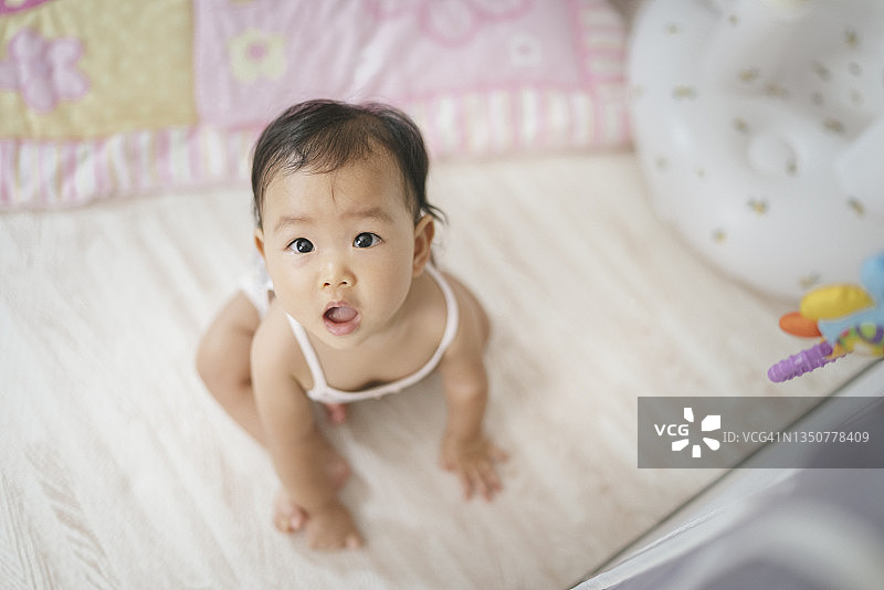 亚洲女婴积极情感地站在卧室内的玩具围栏上生活图片素材