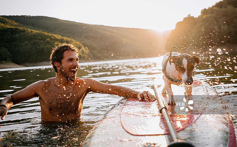 一对带桨板和狗的夫妇图片素材
