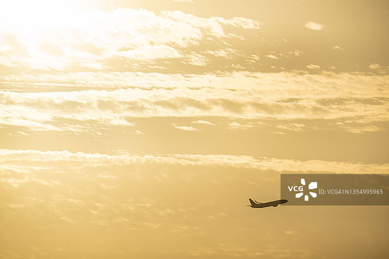 飞机在日本那霸市的日落天空中飞行图片素材
