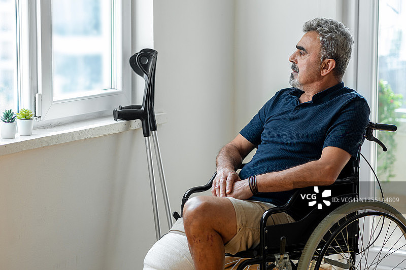 窗前坐轮椅的男人图片素材