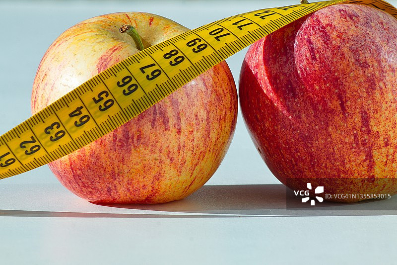 两个美味健康的苹果，周围有一个卷尺图片素材
