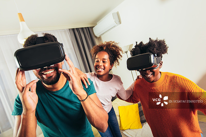 一家人戴着VR眼镜玩视频游戏。图片素材