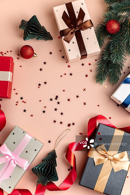 新年的圣诞贺卡。礼品盒和闪亮的装饰在粉红色的背景图片素材