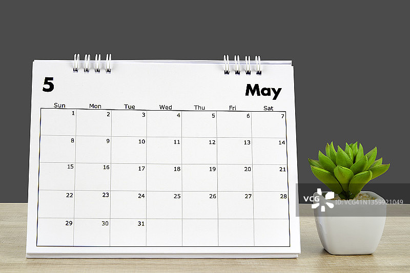 日历桌2022年5月，日历规划和室内植物在深灰色背景木桌上，剪裁路径。图片素材
