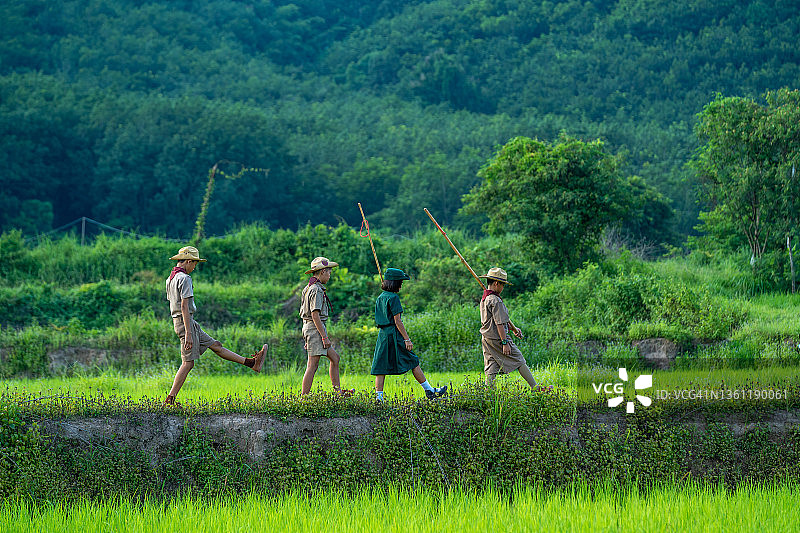 在童军活动开始前，身着童军制服的亚洲学生正在森林中远足。图片素材