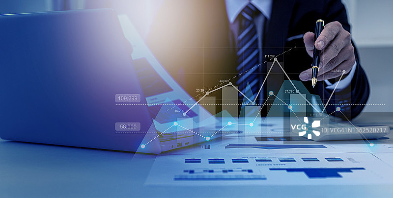一个商人检查财务文件的数据，公司财务报告，显示财务和数字增长数据的图形。财务管理的理念是成长和盈利。图片素材