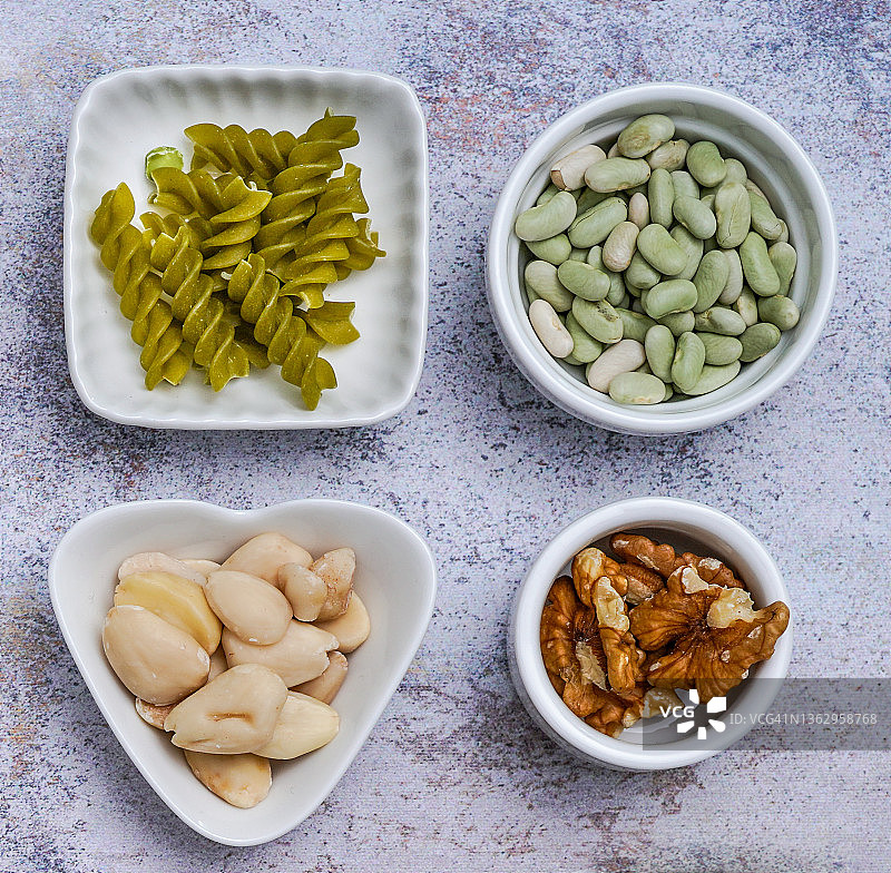 不同形状的白色小碟(意大利面、杏仁、腰果、豆类)挂图的配料展示图片素材