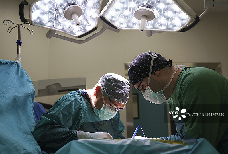 神经外科医生团队在医院手术室进行脑肿瘤手术图片素材