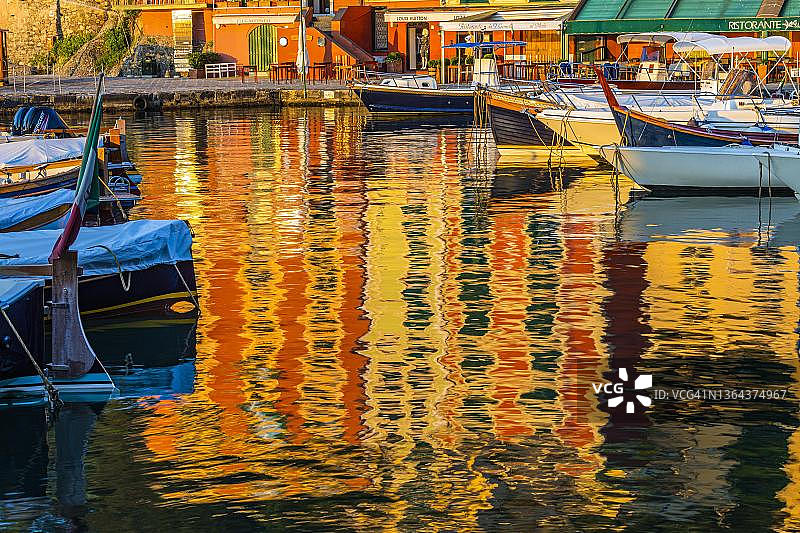 色彩柔和的房屋正面映照在港口Portofino，船只停泊，Portofino，利古里亚，意大利图片素材