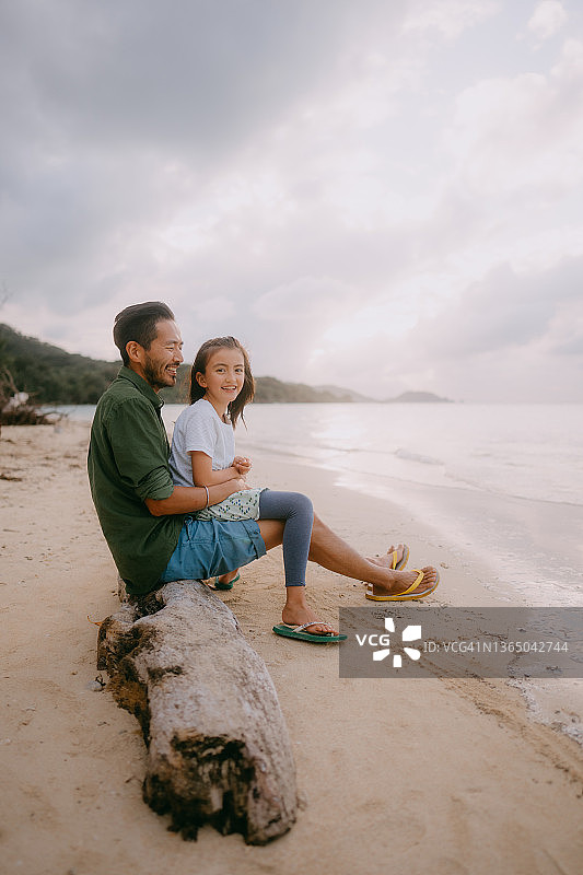 日落时分，父亲和小女儿在海滩上玩得很开心图片素材