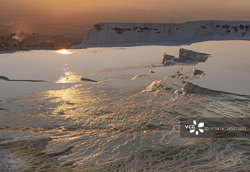 土耳其丹尼兹利省Pamukkale镇，夕阳下的石灰华梯田图片素材