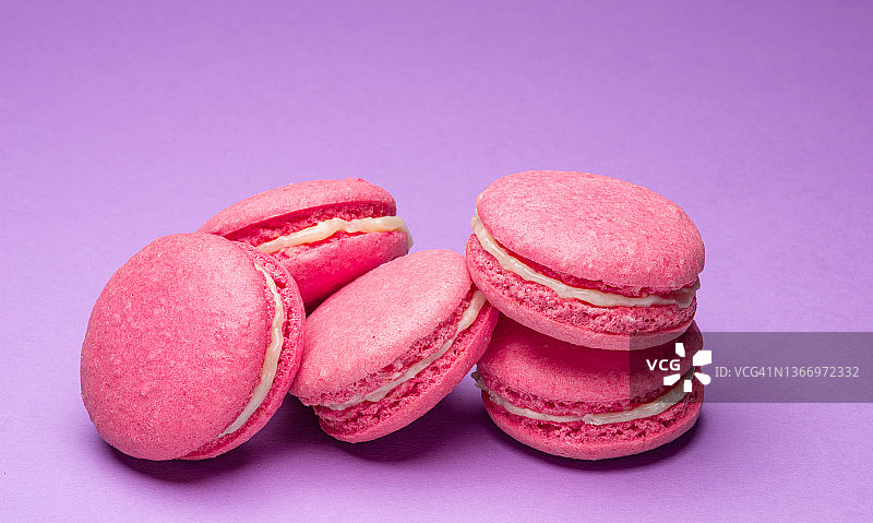 五颜六色的甜马卡龙或马卡龙，紫色背景的调味饼干。图片素材