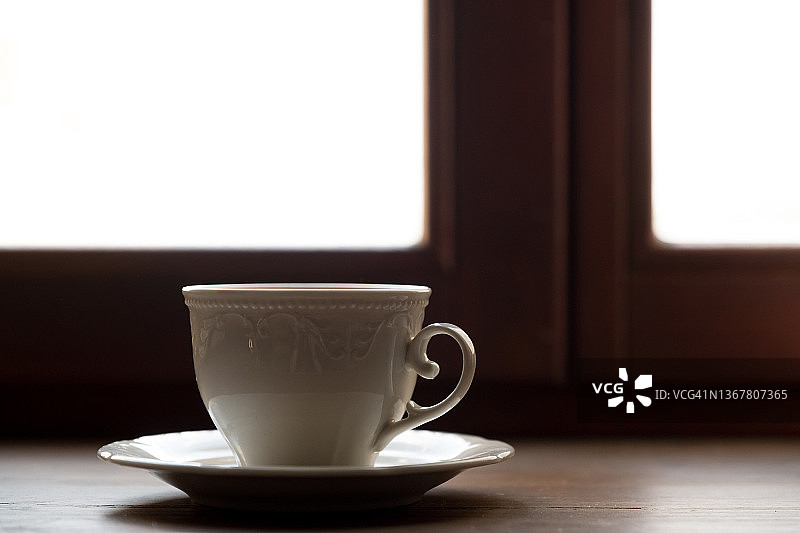 在咖啡馆、自助餐厅或家里，轻木桌上的一杯红茶、菊苣或咖啡。寂寞的概念，早餐。咖啡休息。空间的副本。图片素材