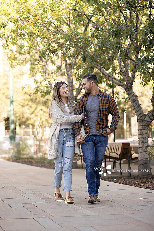 年轻幸福的夫妇在城市公园散步图片素材