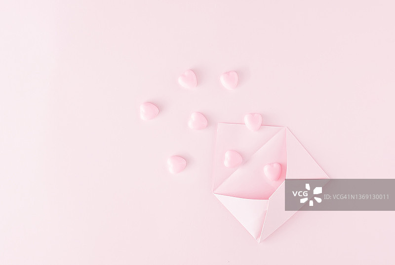 情人节爱的创意最小概念打开浅粉色信封与心在相同的颜色背景。平的。副本的空间。图片素材