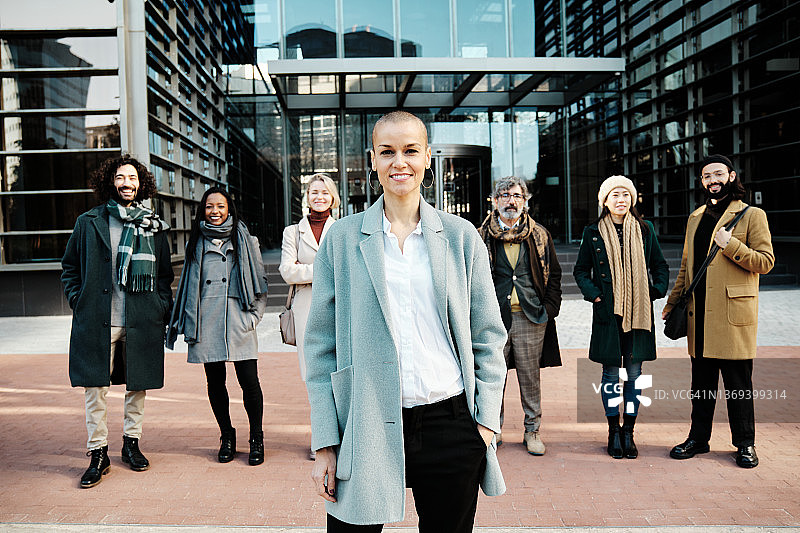 在金融区，女商业领袖从一群商业人士中脱颖而出。图片素材