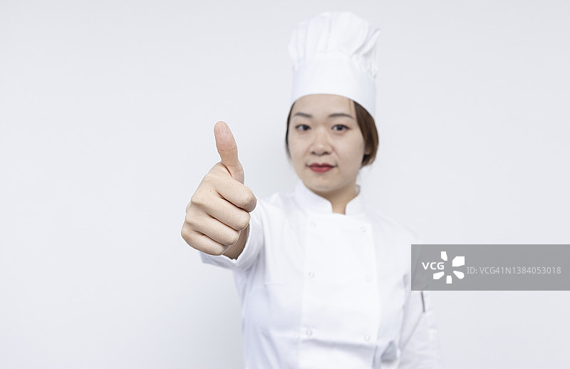 亚洲美丽的女厨师做大拇指图片素材