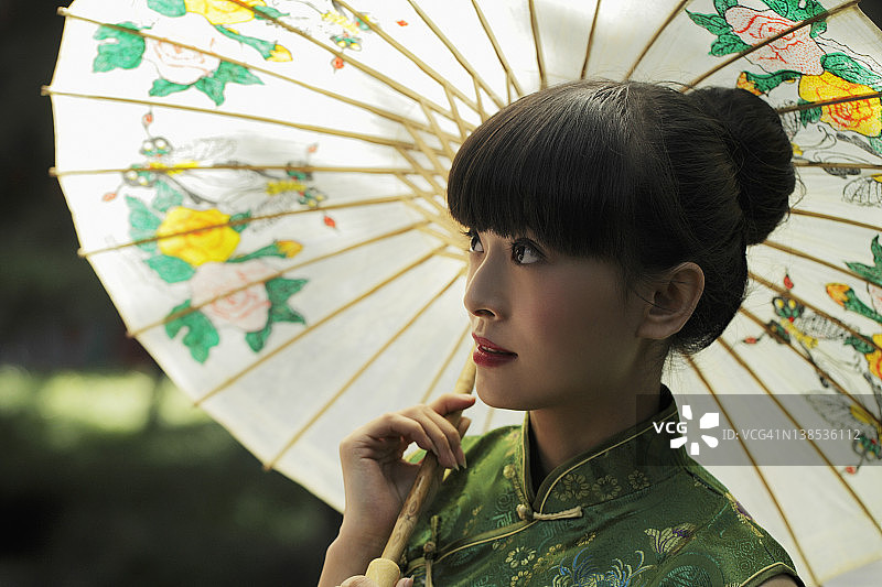 年轻女子穿着中国传统服饰，拿着伞图片素材