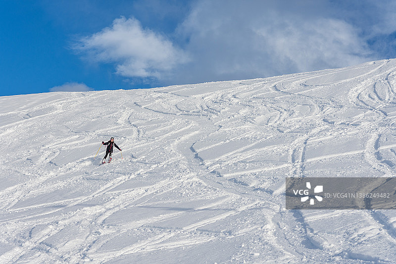 挪威，一名女子从雪山上滑雪而下图片素材